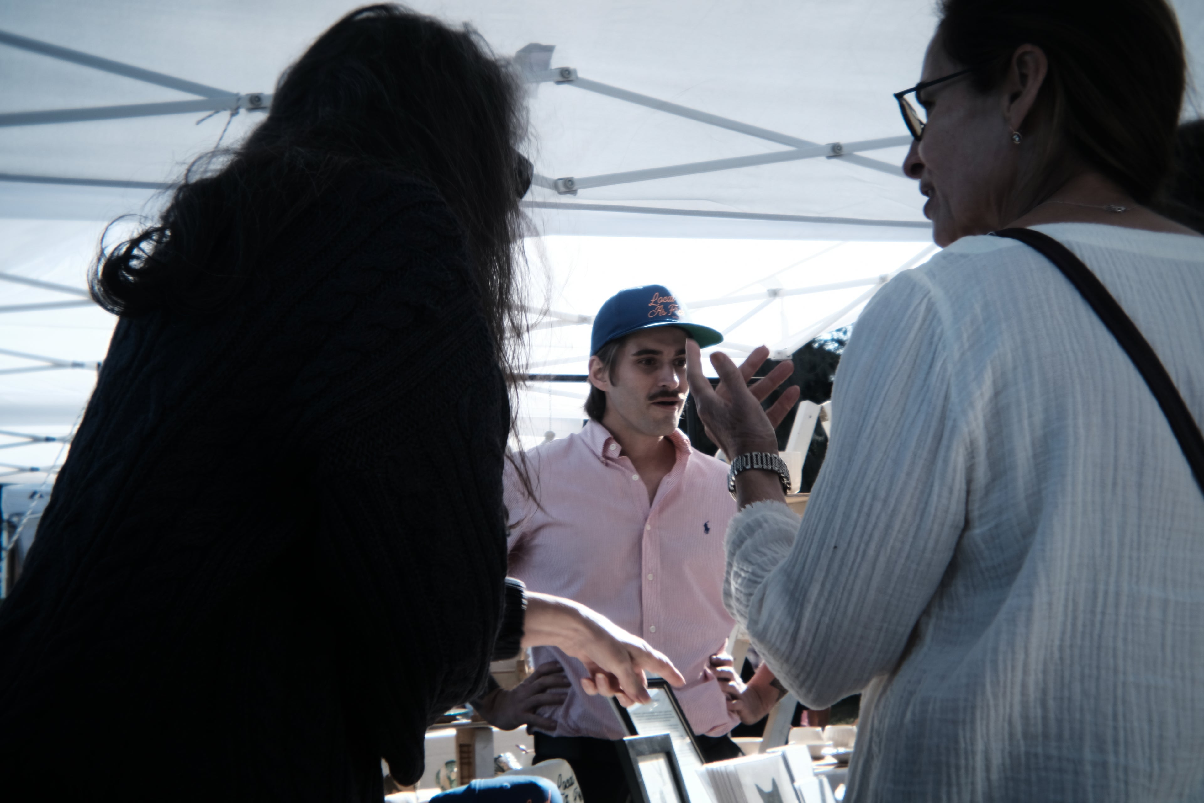 Brooks Davis II talking with customers at his booth, Isle of Hope Art and Music Festival